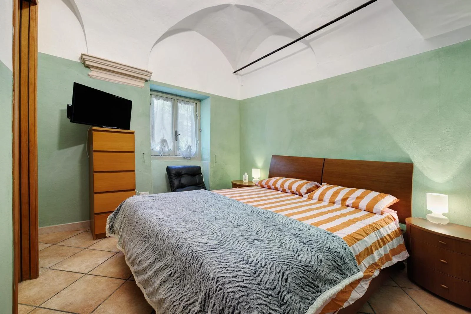 Camera Verde: letto matrimoniale con pareti verdi, soffitto a volta e finestra