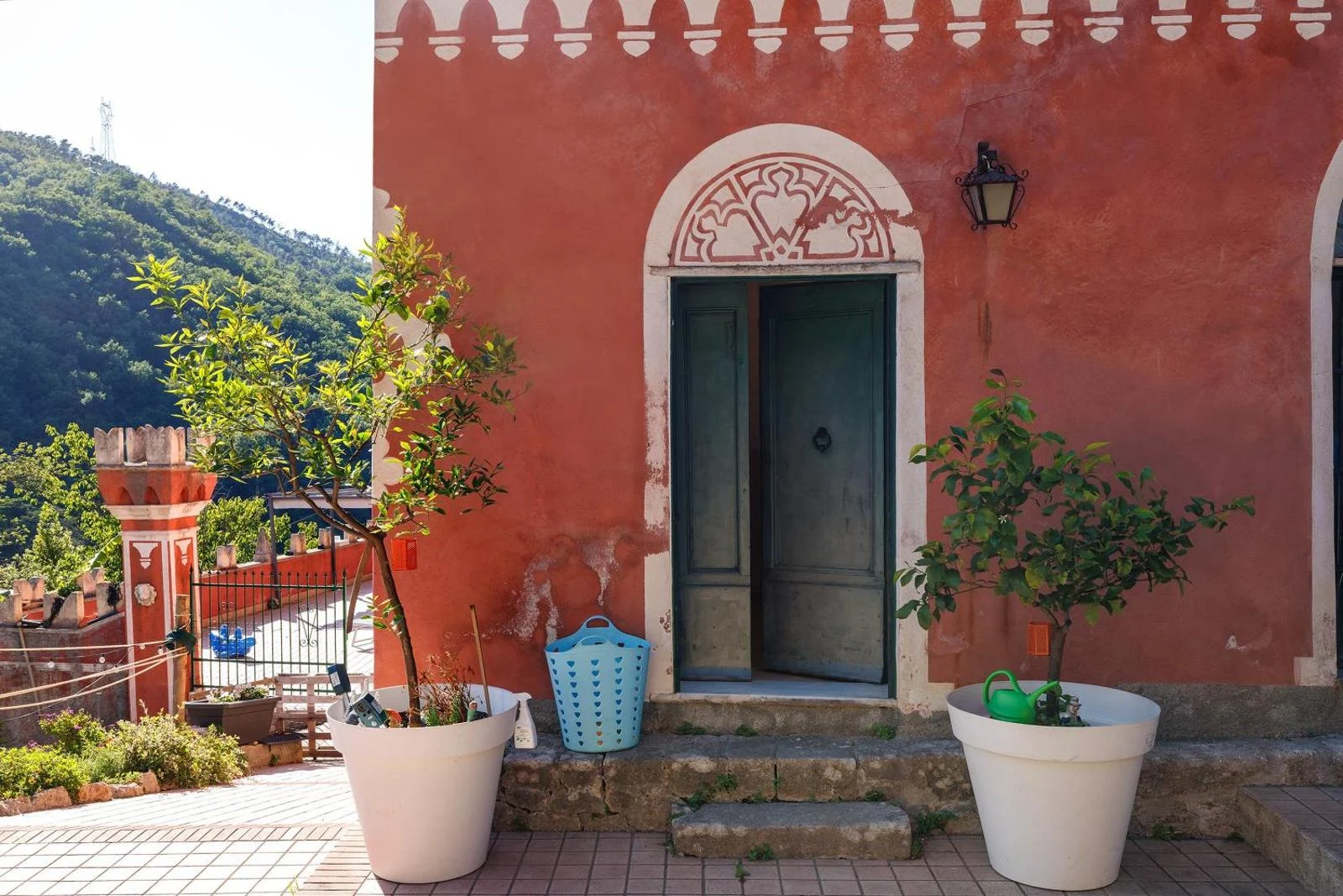 L’ingresso di Villa Piuma: portone verde, muri corallo e decori bianchi