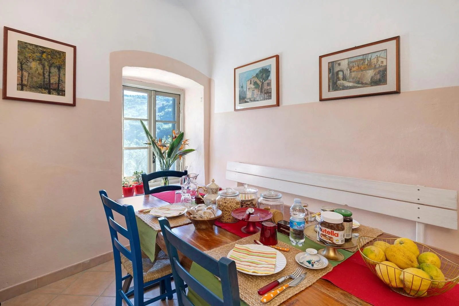 La sala della colazione di Villa Piuma con tavolo apparecchiato e sedie azzurre