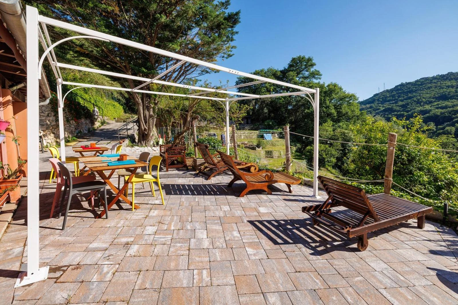 Tavoli e sedute sulla terrazza con vista sulle colline